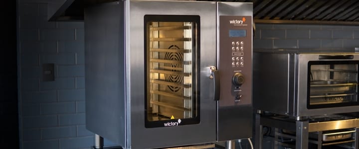 Forno combinado industrial da marca Wictory em aço inox, com painel digital de controle e visor de vidro amplo em uma cozinha profissional.