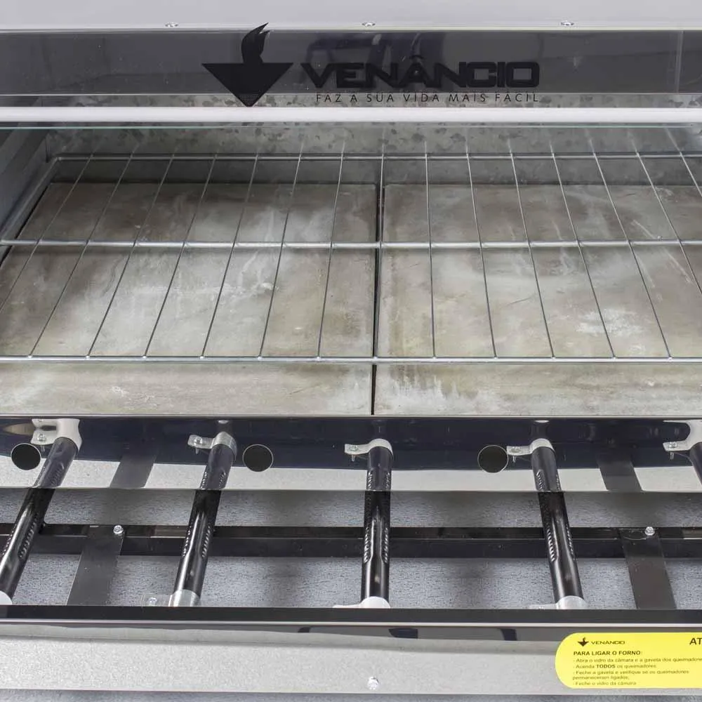 Vista interna do forno Venâncio Roma exibindo as pedras refratárias de base e o sistema de queimadores tubulares inferiores para distribuição de calor.