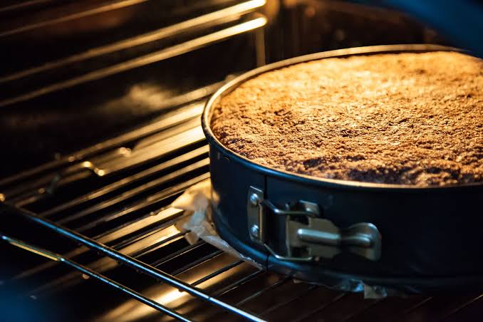 olo crescendo de forma uniforme dentro de uma forma com trava ajustada na grade do forno pré-aquecido e iluminado.