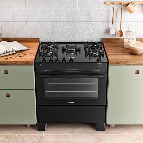 Fogão Atlas Mônaco Top Glass 5 Bocas preto com mesa de vidro, integrado em cozinha moderna de confeitaria