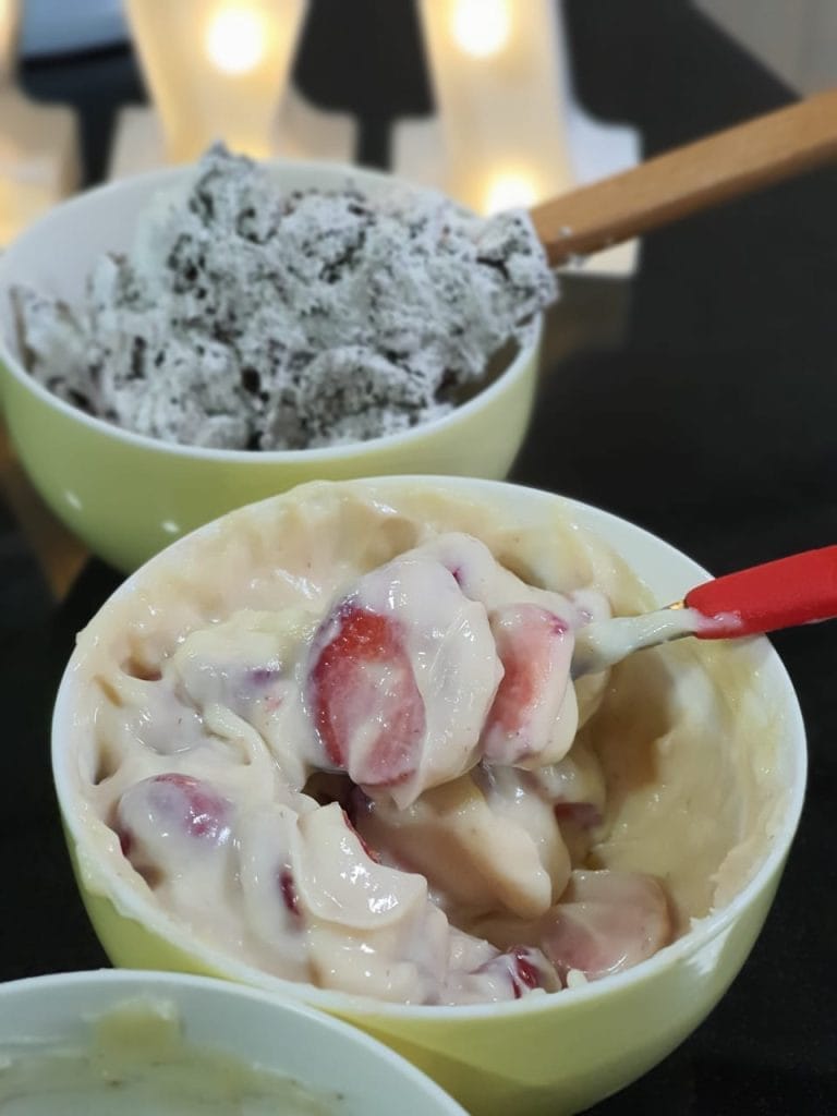 Duas tigelas pequenas, uma com recheio cremoso de leite ninho e morango, e outra com um recheio de chocolate e biscoito.
