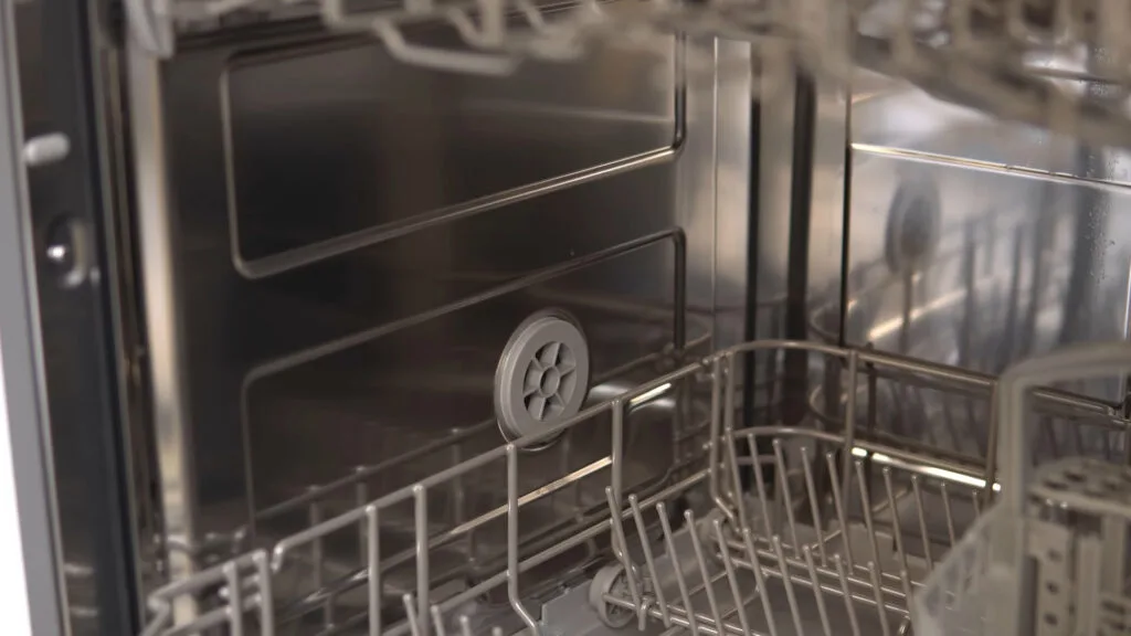 Visão interna detalhada da lava-louças Midea 14 serviços destacando o revestimento em aço inoxidável e os braços aspersores de lavagem.