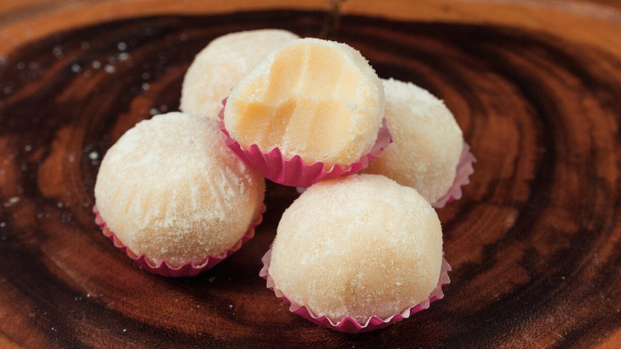 Brigadeiro de Leite Ninho cortado ao meio, mostrando a textura aveludada e cremosa do recheio. Receita perfeita para enrolar e vender.