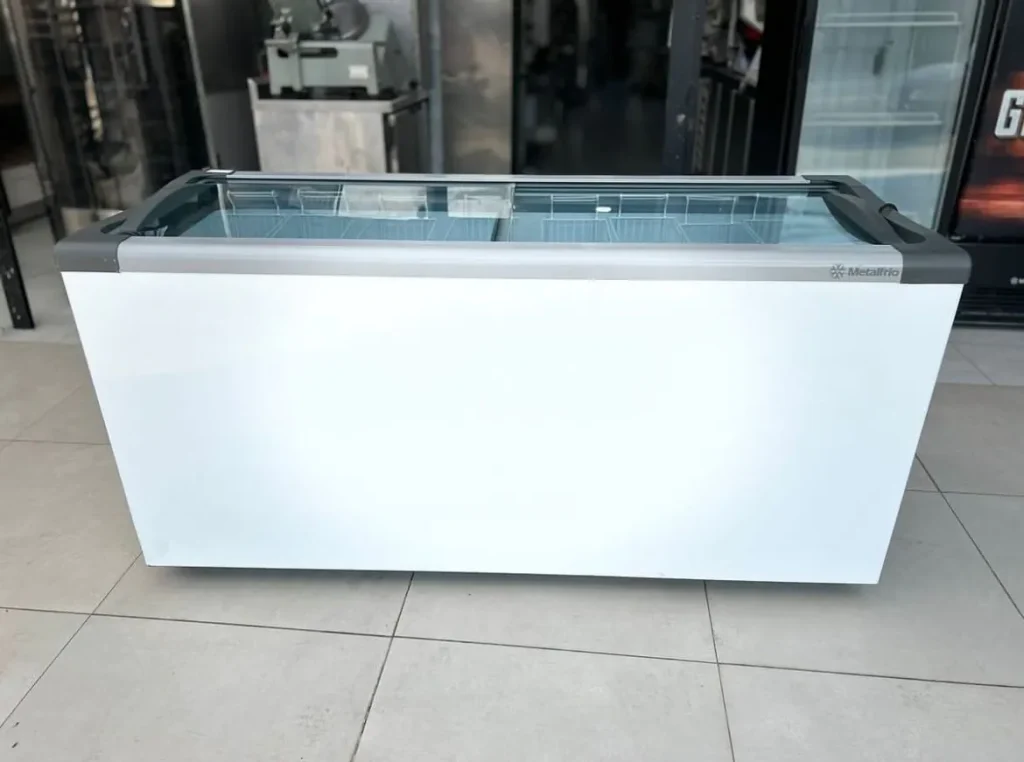 Freezer horizontal Metalfrio NF branco com tampa reta de vidro deslizante, ideal para exposição e conservação de sorvetes, picolés e açaí em sorveteria e açaiteria.