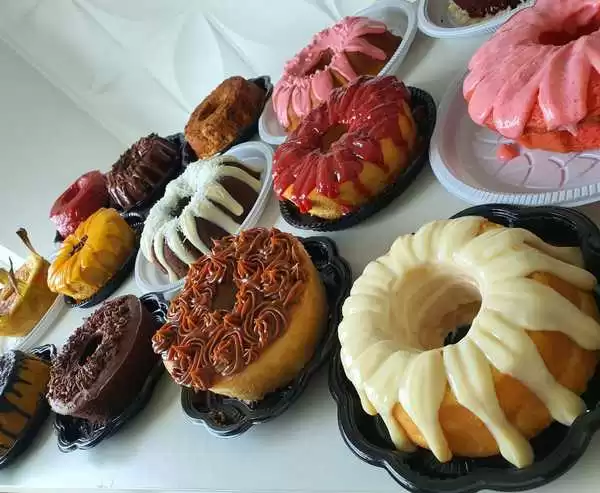 Variedade de bolos caseiros com coberturas coloridas, ideais para vendas e para ilustrar uma apostila de bolos caseiros lucrativa para confeiteiros