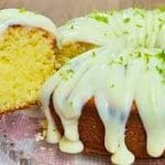 Close-up da cobertura para bolo de limão durinha em efeito gotejante (drip cake) sobre um bolo fofinho, finalizada com raspas de limão.