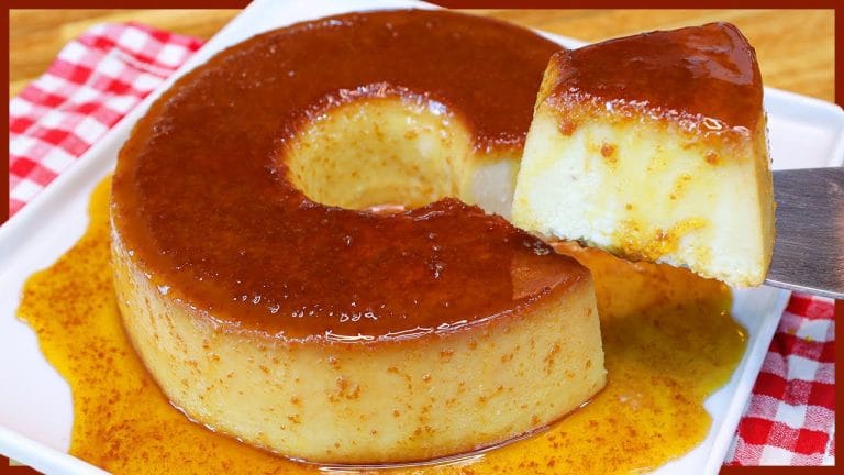 Pudim de pão cremoso com calda de caramelo dourada, uma fatia recém-tirada da forma revelando a textura macia. Receita de pudim de pão de liquidificador perfeita para sobremesa.