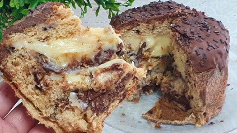 Foto detalhada de chocotone recheado com cobertura de glacê de limão escorrendo e raspas de limão por cima. Demonstra a textura cremosa e o acabamento gourmet.