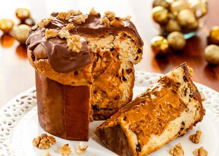 Panetone gourmet trufado com recheio cremoso e farto de doce de leite com nozes, coberto com chocolate e decorado com metades de nozes. Ideal para vendas de Natal.