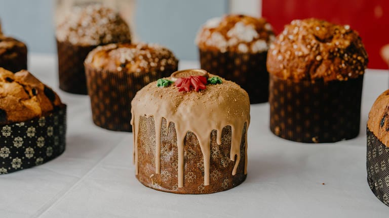 Chocotone Trufado com cobertura de chocolate e granulado, embalado em caixa transparente para presente. O formato ideal para Vendas Corporativas (B2B), otimizando a Logística e o Presente de Empresa no Natal.