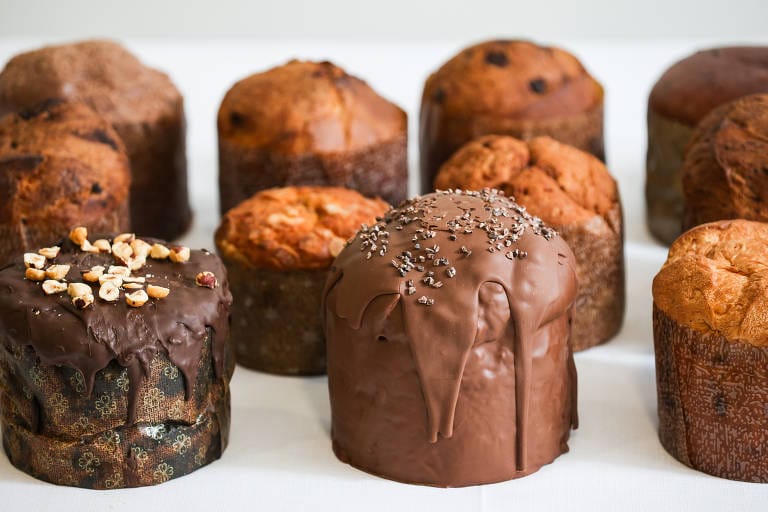 Variedade de Panetones Zero Açúcar, Sem Glúten e Sem Lactose decorados com coberturas. As receitas base adaptadas permitem criar um cardápio completo, garantindo a segurança e o alto lucro no nicho.