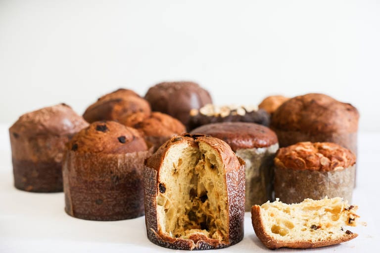 Quatro mini panetones Sem Glúten ou Zero Açúcar artesanais polvilhados em um prato. O volume e a qualidade do produto garantem a Fidelidade do cliente e um Faturamento Consistente, elevando a marca à Autoridade Máxima no nicho.