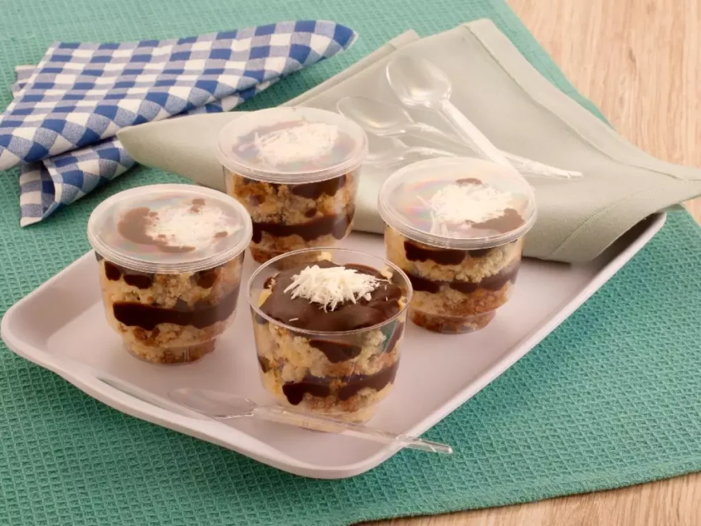 Ampla variedade de Bolos no Pote gourmet de diversos sabores, prontos para a venda. A imagem demonstra o potencial de Diversificação para maximizar a Visibilidade no Delivery (Ifood e Rappi) e aumentar a Escala de Vendas.