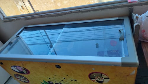 Freezer horizontal expositor com tampa de vidro reta e envelopamento de sorvetes. O formato reto facilita a remoção da condensação e simplifica a limpeza das bordas para manutenção da visibilidade.