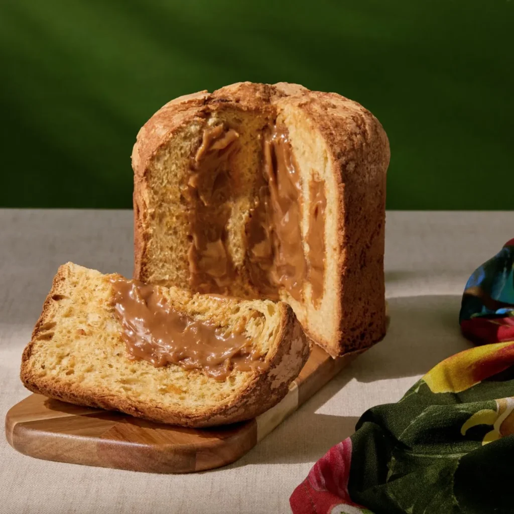 Fatia de Panetone Doce de Leite recheado, destacando o recheio que escorre. A imagem ilustra a receita gourmet com Flor de Sal, que eleva o sabor e justifica o preço mais elevado.