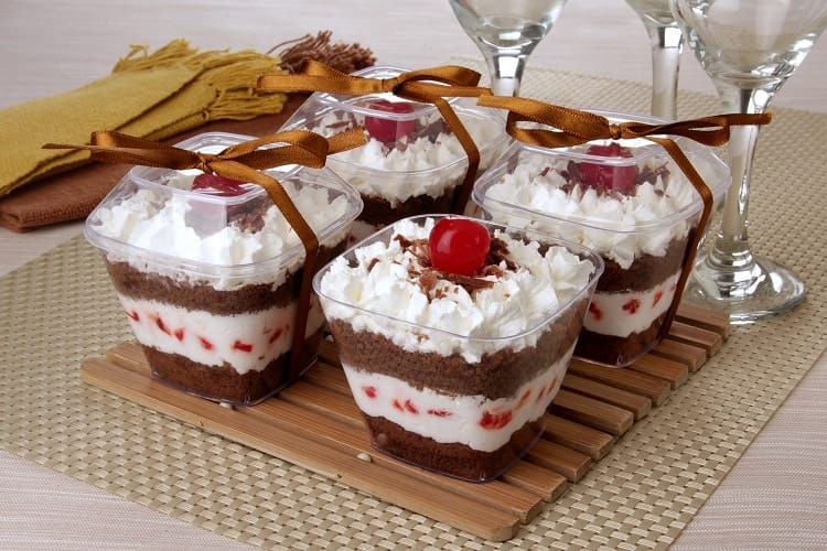 Quatro bolos no pote sabor Floresta Negra em embalagens plásticas quadradas transparentes com tampas. Ideal para armazenamento, congelamento e garantir a validade e o frescor do produto por mais tempo.