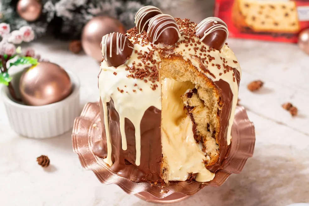 Chocotone trufado gourmet ricamente decorado com casca de chocolate preto escorrendo e pedaços de chocolate branco. A imagem demonstra um produto de Alto Lucro e Formato Inovador para escalar as vendas.