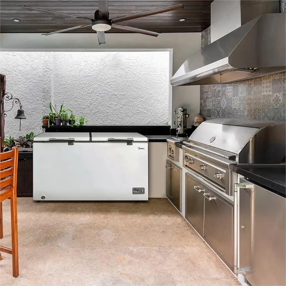 Freezer horizontal Midea branco de duas portas em uma cozinha industrial ao lado de fornos profissionais e, em detalhe, integrado a uma área gourmet moderna com churrasqueira.