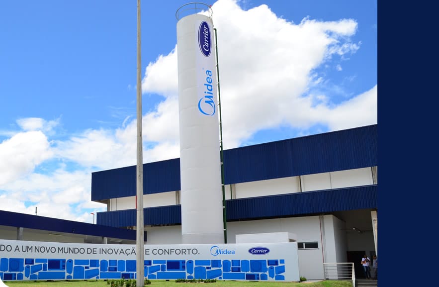 Fachada da unidade fabril da Midea Carrier, destacando a grande infraestrutura de produção e o compromisso com inovação e conforto.